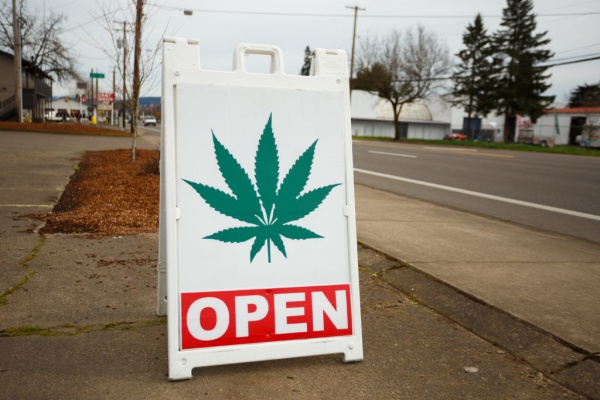 Outdoor sign with a cannabis leaf placed outside a dispensary